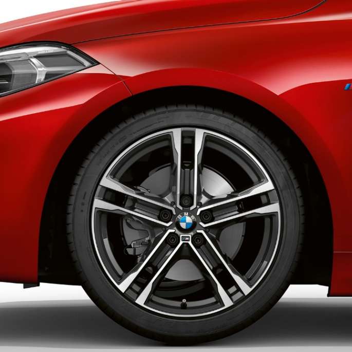 BMW Serie 1 Modelo M Sport, frontal de lado. BMW Serie 1 Modelo M Sport en Melbourne Red metálico, frontal desde el costado con llantas de aleación ligera M de 17 pulgadas Double-spoke estilo 550 M en Bicolor.