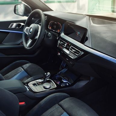 Interior deportivo del BMW Serie 1. Cabina del BMW Serie 1 con asientos M Sport, volante de cuero M y acabados interiores iluminados en vestiduras.