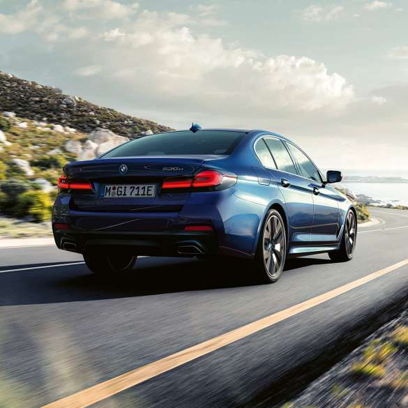 Dinámica de conducción BMW Serie 5 Sedan G30 Dinámica de conducción BMW Serie 5 Sedan G30 Vista trasera de tres cuartos de conducción azul fítico