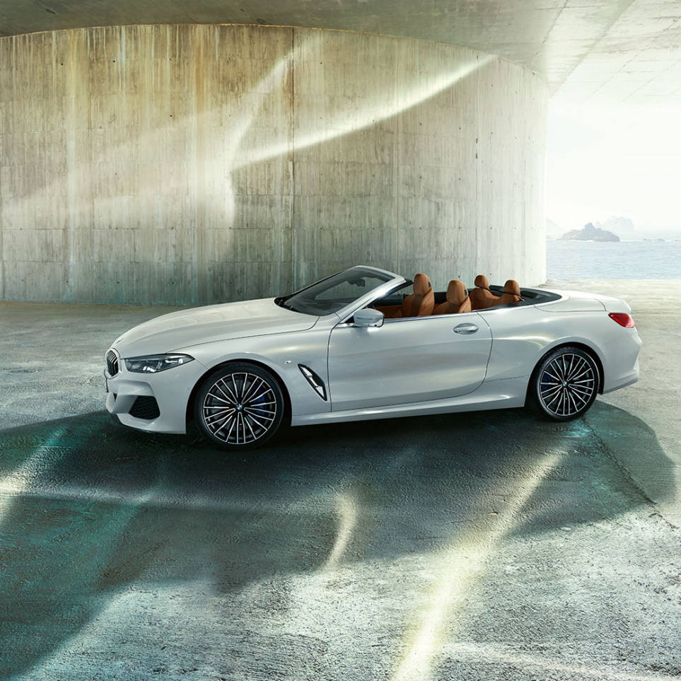 BMW M850i xDrive en Blanco Mineral metálico, vista lateral con la capota suave abierta. BMW M850i xDrive en Blanco Mineral metálico, vista lateral con la capota suave abierta.