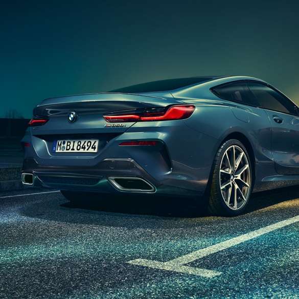 BMW Serie 8 Coupé, vista trasera de tres cuartos. BMW Serie 8 Coupé, vista trasera de tres cuartos, detenido frente a un escenario nocturno.