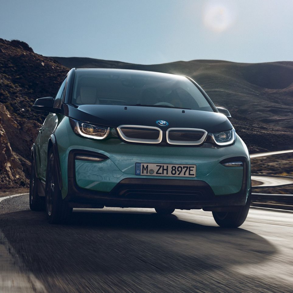 BMW i3 2018, vista lateral, en marcha BMW i3 I01 2018 Jucarobeige con detalles Frozen Grey metalizado, vista lateral, en marcha en un entorno urbano