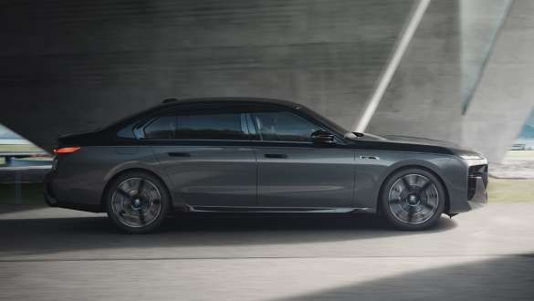 Autonomía eléctrica BMW M760e xDrive Berlina G70 Paquete M Performance Autonomía eléctrica BMW M760e xDrive Berlina G70 Paquete M Performance BMW Individual Black Sapphire metalizado bitono, pintura BMW Individual Dravit Grey metalizado, vista lateral circulando por la calle