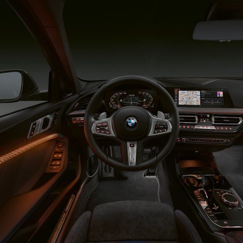 BMW M135i xDrive, cabina. Interior premium del BMW M135i xDrive con acabados interiores iluminados.