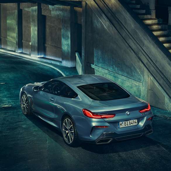 BMW M850i xDrive Coupé, vista posterior izquierda tres cuartos. BMW M850i xDrive Coupé en Barcelona Blue metálico, vista posterior izquierda tres cuartos, en alto de noche.