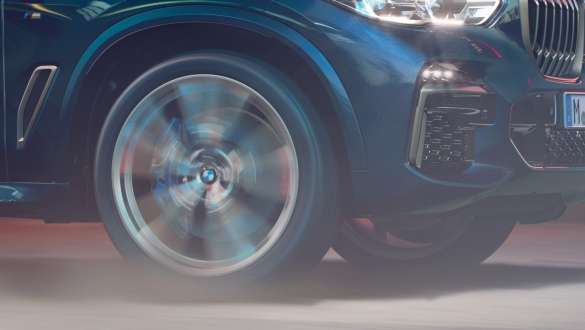 BMW X5 M50i con suspensión adaptable M BMW X5 M50i con suspensión adaptable M en color Carbon black metálico acercamiento del rin