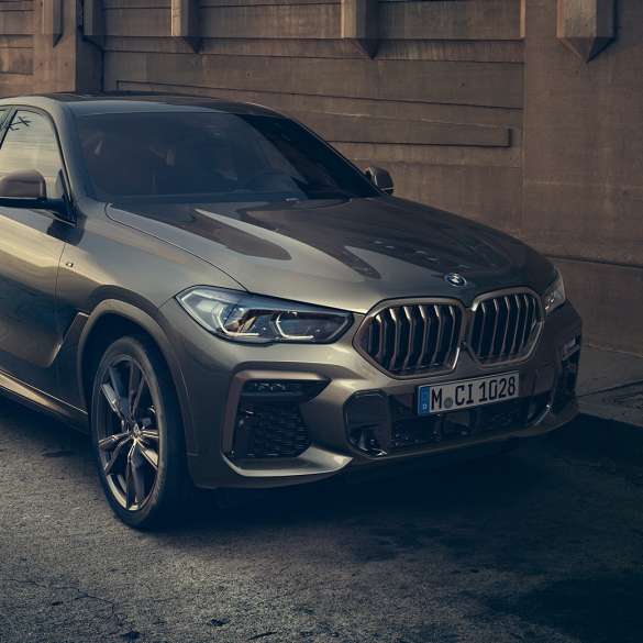 BMW X6 M50i con motor de gasolina de 8 cilindros M TwinPower Turbo Vista lateral de tres cuartos del BMW X6 M50i con motor de gasolina de 7 cilindros M TwinPower Turbo G06 Manhattan metálico