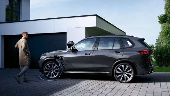 Híbrido enchufable BMW X5 xDrive45e G05 Vista del lateral, delante del garaje Híbrido enchufable BMW X5 xDrive45e G05 Vista del lateral, delante del garaje con modelo