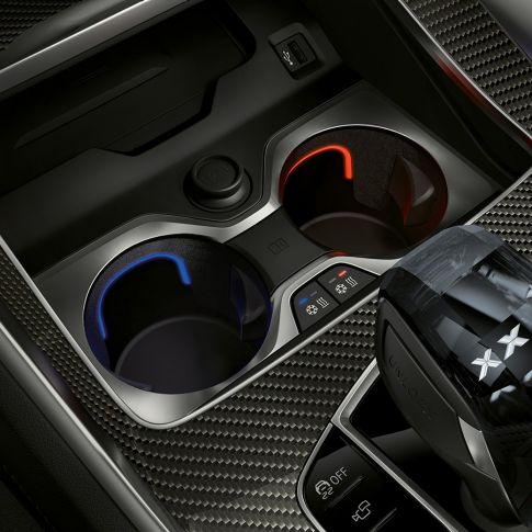 Portavasos con control de temperatura. Acercamiento del interior del BMW con enfoque en el portavasos con control de temperatura.