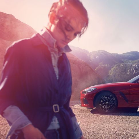 BMW Z4 Roadster frente a una vista montañosa Hombre y mujer y el BMW Z4 Roadster frente a una vista montañosa