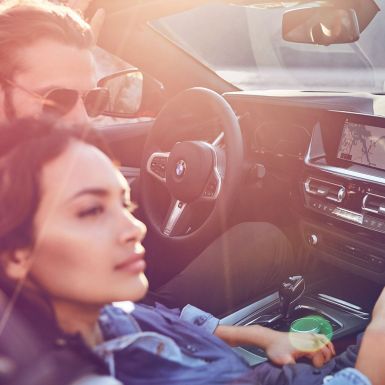 Mujer y hombre en el BMW Z4 Roadster Mujer de cabello oscuro y hombre en el BMW Z4 Roadster