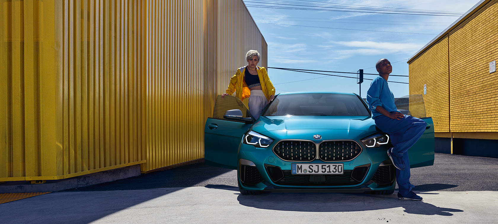 BMW Serie 2 Gran Coupé F44, vista del frontal BMW Serie 2 Gran Coupé F44 Snapper Rocks Blue metalizado, vista del frontal con las puertas abiertas y dos personas en el vehículo