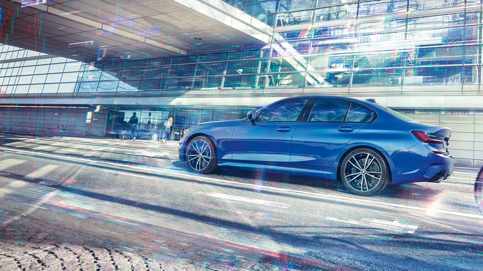 BMW Serie 3, vista del lateral Imagen del lateral de la Sedán deportiva BMW Serie 3 de día delante de un edificio de cristal.