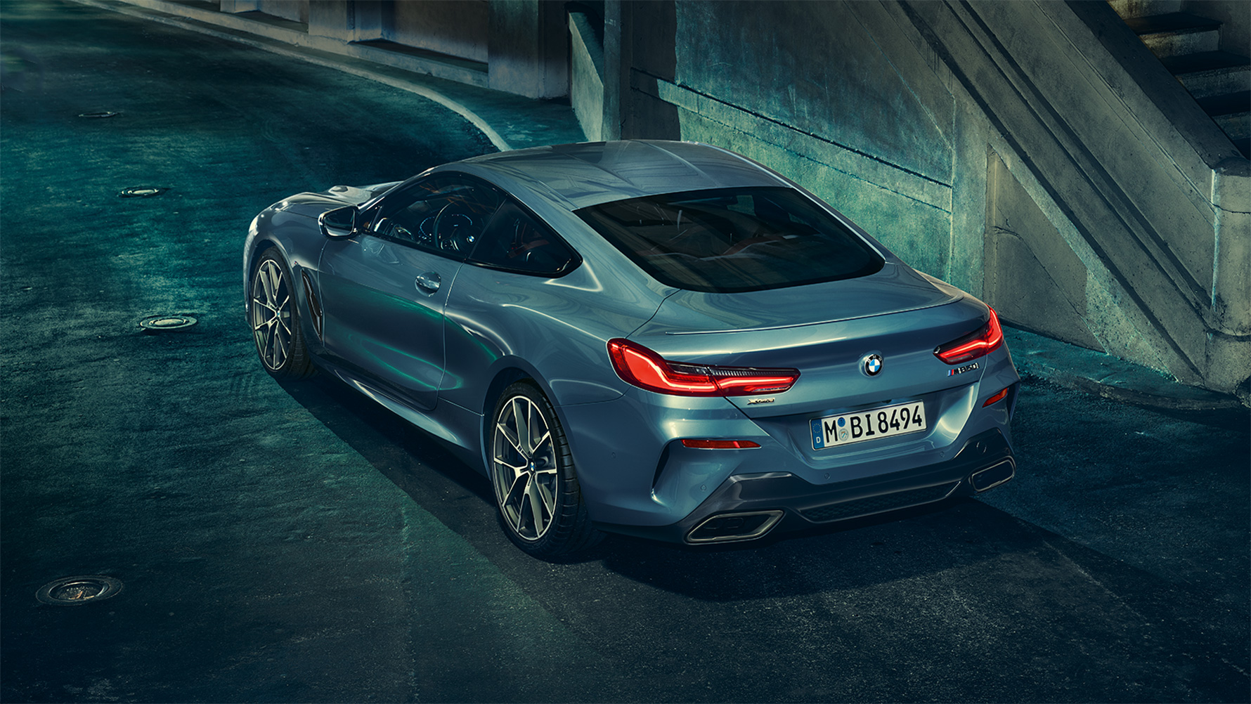 BMW Serie 8 Coupé, imagen trasera de tres cuartos Imagen trasera de tres cuartos del BMW Serie 8 Coupé de noche frente a un escenario urbano.