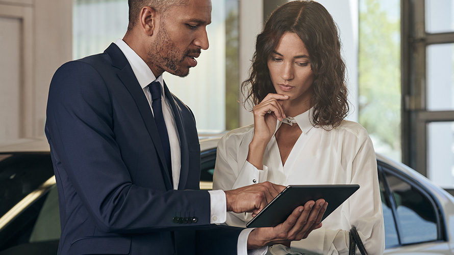 Empleado de servicio de BMW asesora a una clienta Empleado de servicio de BMW asesora a una clienta