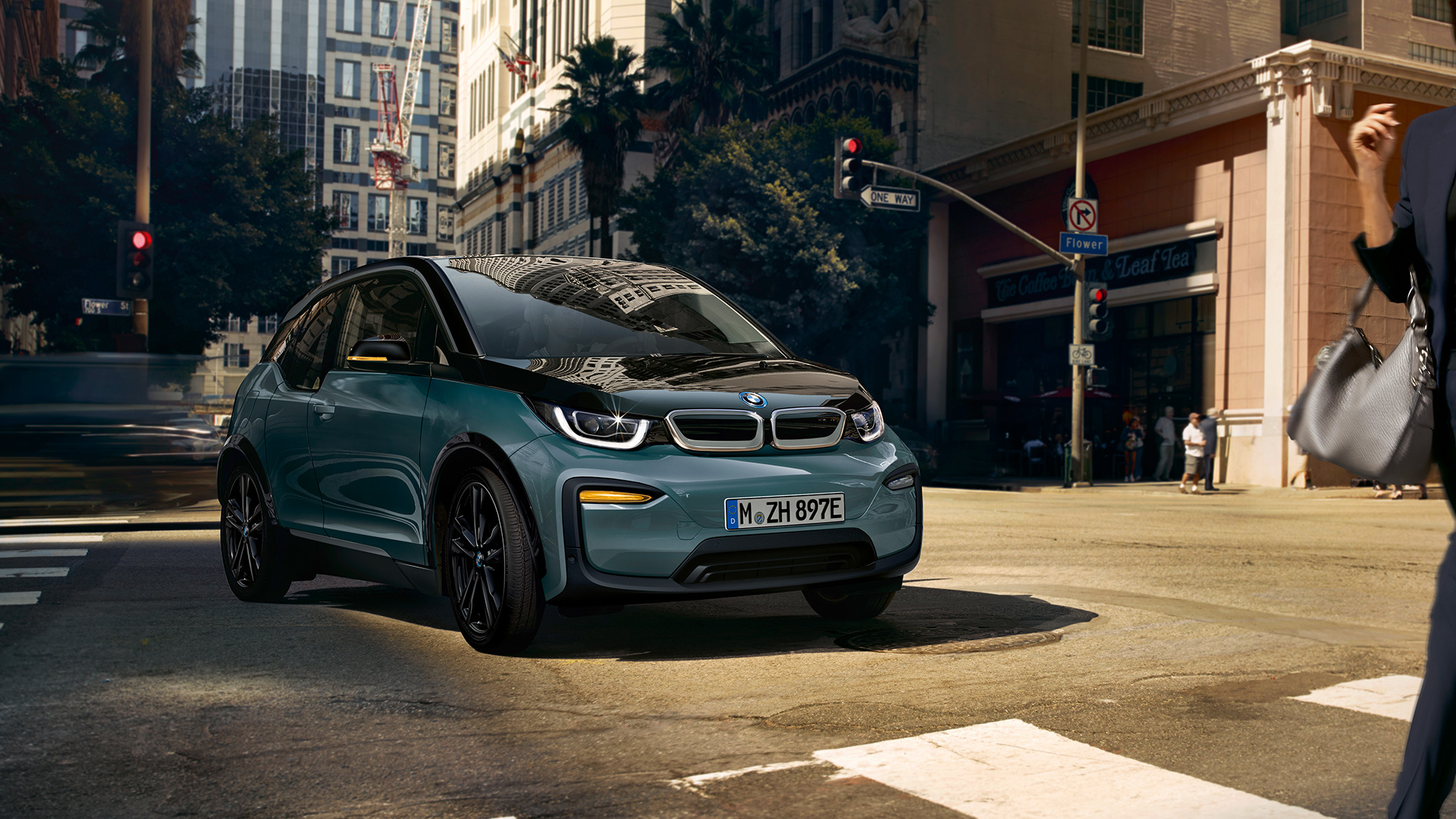 BMW i3 2018 Vista de tres cuartos del frontal, en marcha BMW i3 I01 2018 Jucarobeige con detalles Frozen Grey metalizado, vista de tres cuartos del frontal, en marcha en un entorno urbano