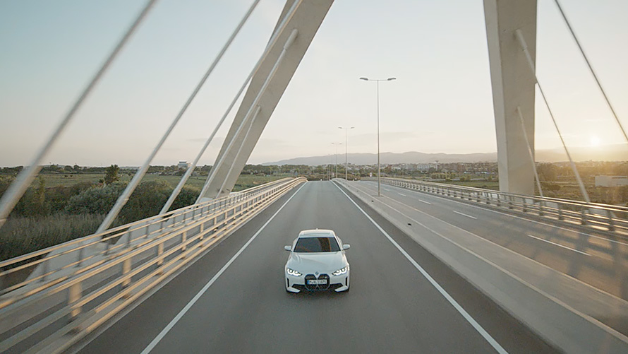 Vista de tres cuartos del frontal BMW i4 eDrive40 G26 2021, en marcha BMW i4 eDrive40 G26 2021 Mineralweiss, vista de tres cuartos del frontal, en marcha