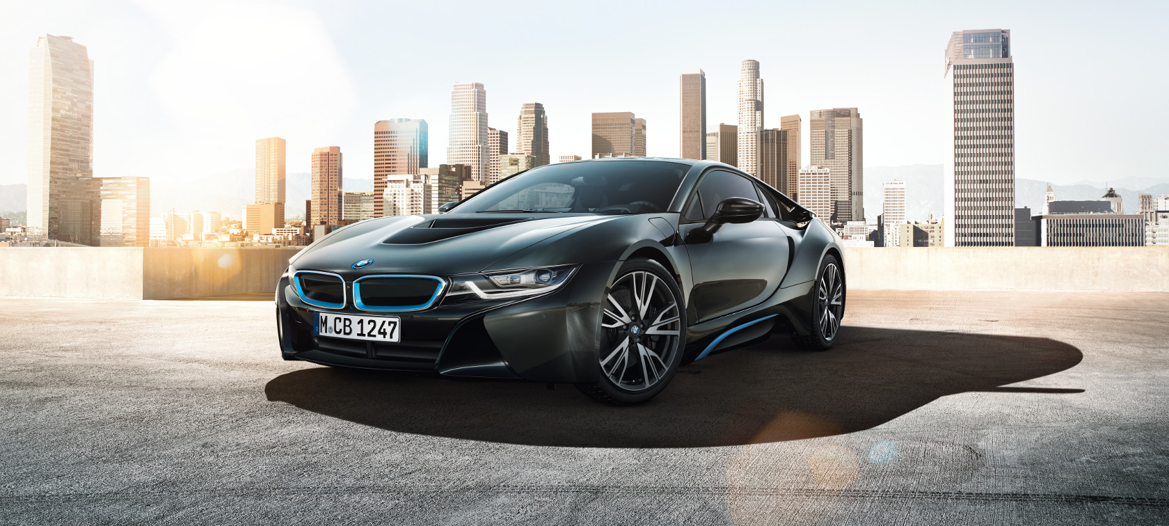 BMW i8 negro: vista frontal con rascacielos al fondo BMW i8 negro: vista frontal con rascacielos al fondo