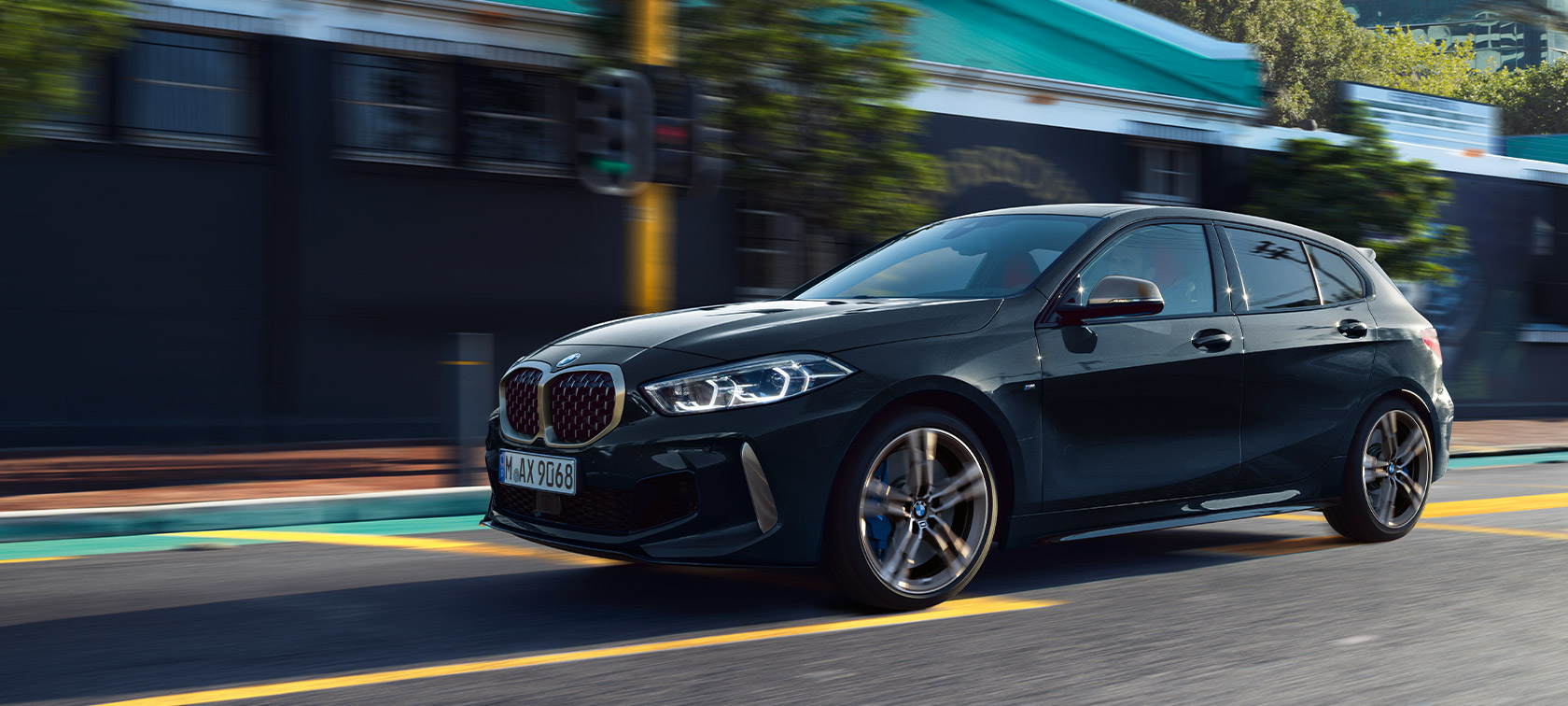 BMW Serie 1 M135i xDrive (F40) en Black Sapphire metalizado, vehículo en marcha en un entorno urbano 