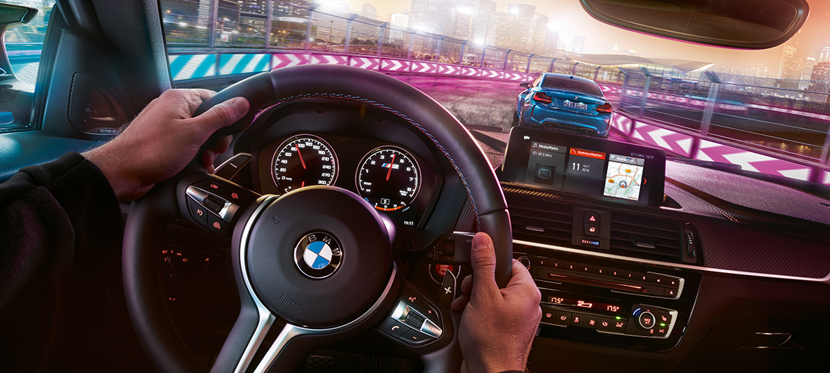 Cockpit del BMW M2 Competition. Dos BMW M2 Competition, compitiendo de noche, vista desde el cockpit.