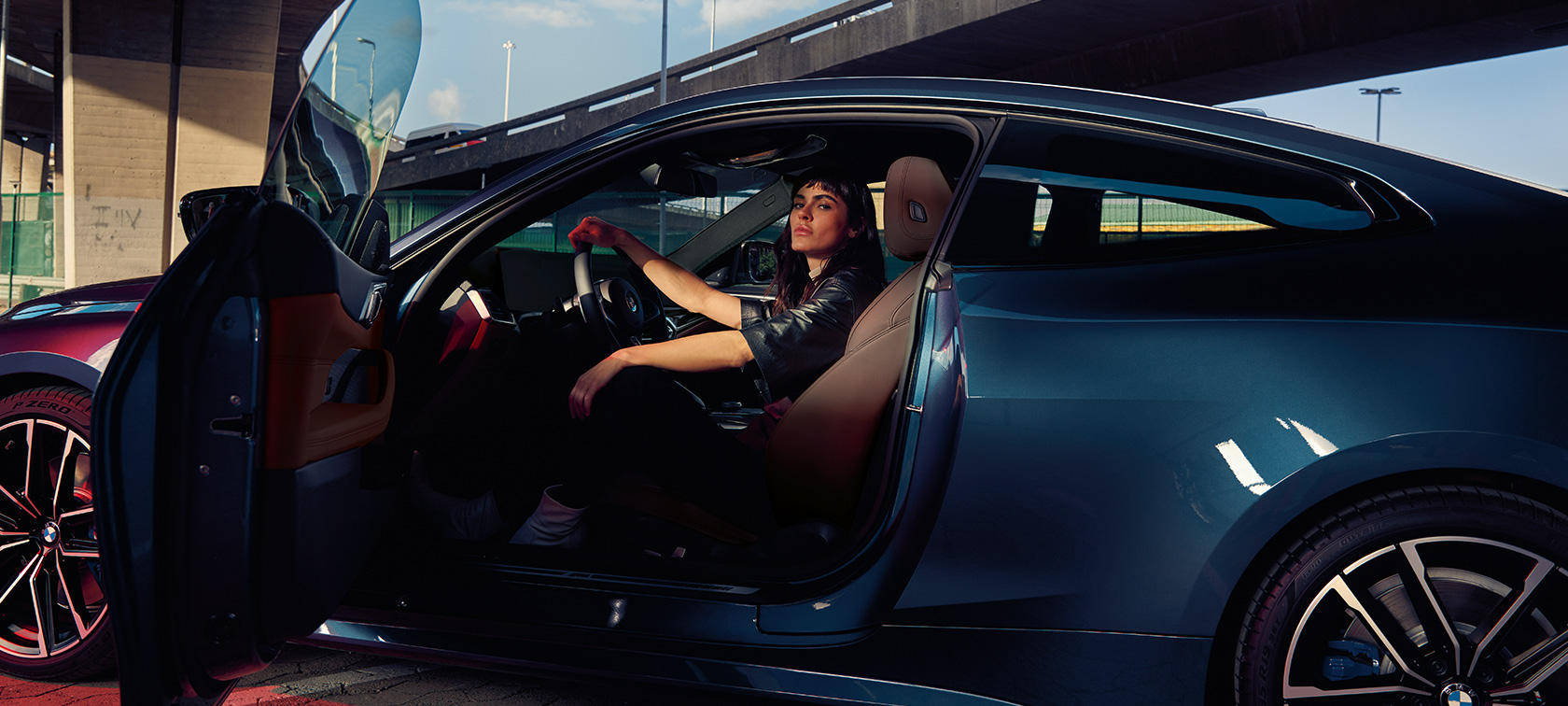 BMW M440i xDrive Coupé G22 2020 Vista lateral Modelo sentado en el coche con la puerta abierta BMW M440i xDrive Coupé G22 2020 Arctic Race Blue metalizado Vista lateral Modelo en el asiento de un coche con la puerta abierta