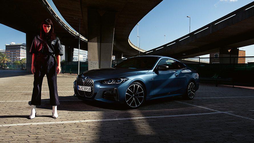 BMW Serie 4 Coupé G22 2020 Vista de tres cuartos del lateral con modelo al lado