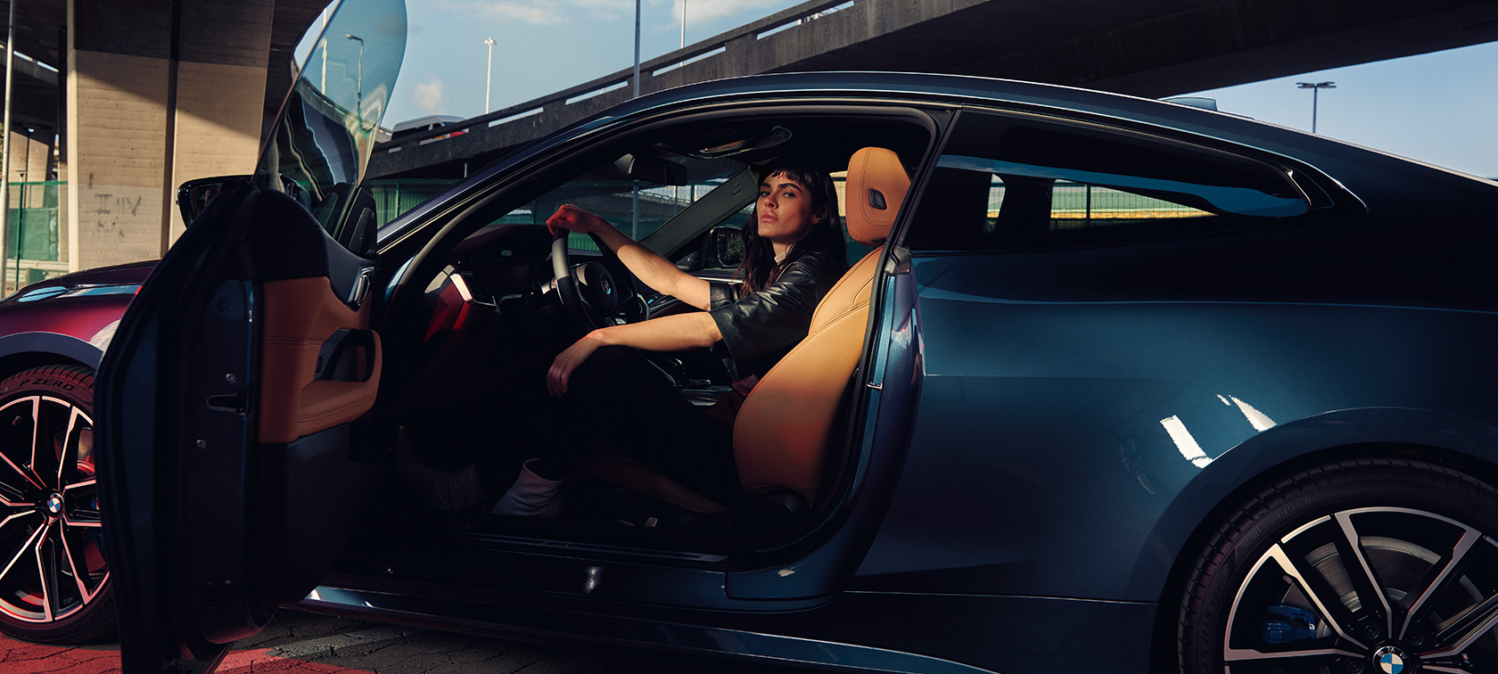 Vista lateral con modelo BMW M440i xDrive Coupé G22 2020 BMW M440i xDrive Coupé G22 2020 Arctic Race Blue metalizado Vista lateral Modelo en el asiento de un coche con la puerta abierta