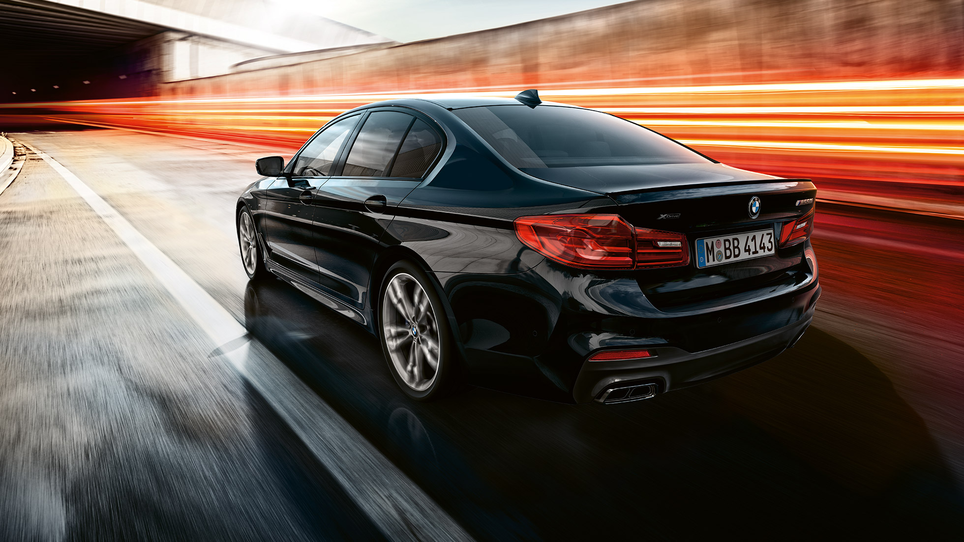 Dinámica de conducción. Toma trasera de tres cuartos en movimiento del BMW M550i y del BMW M550d.
