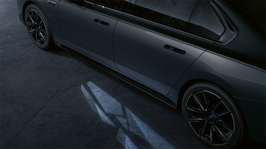 Concepto de iluminación BMW M760e xDrive Berlina G70 BMW Individual bicolor Black Sapphire metalizado, pintura BMW Individual Dravit Grey metalizado, detalle de la vista lateral con Welcome Light Carpet encendida