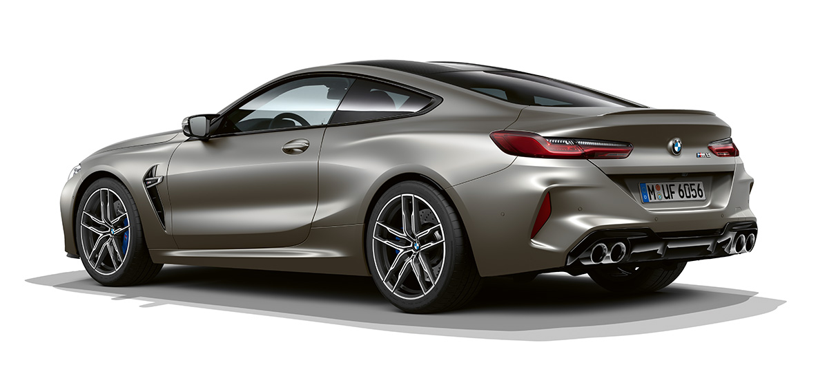 BMW M8 Coupé, vista lateral tres cuartos desde la parte trasera. BMW M8 Coupé en Frozen Dark Silver, vista lateral tres cuartos desde la parte trasera.