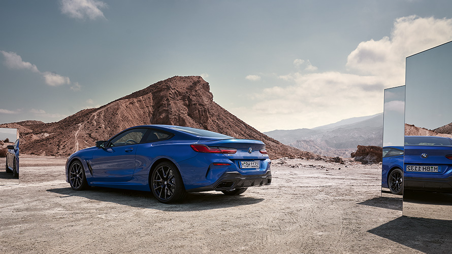 Nuevo BMW M850i xDrive Coupé G15 LCI Renovación 2022 M Portimao Blue metalizado, vista de la zaga, parado, con espejos