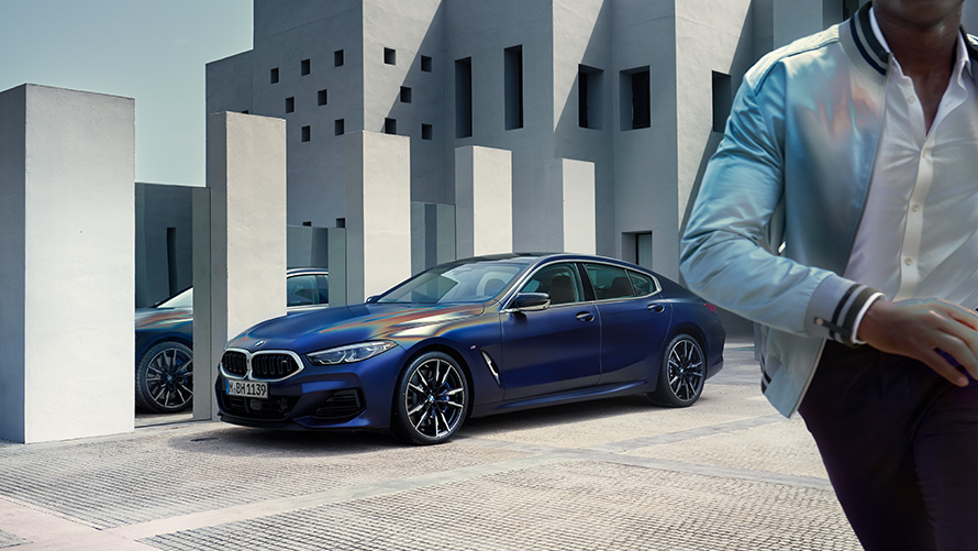 Nuevo BMW M850i xDrive Gran Coupé G16 LCI Renovación 2022 BMW Individual Frozen Tanzanite Blue metalizado, vista de tres cuartos del frontal, parado, con modelo masculino en primer plano