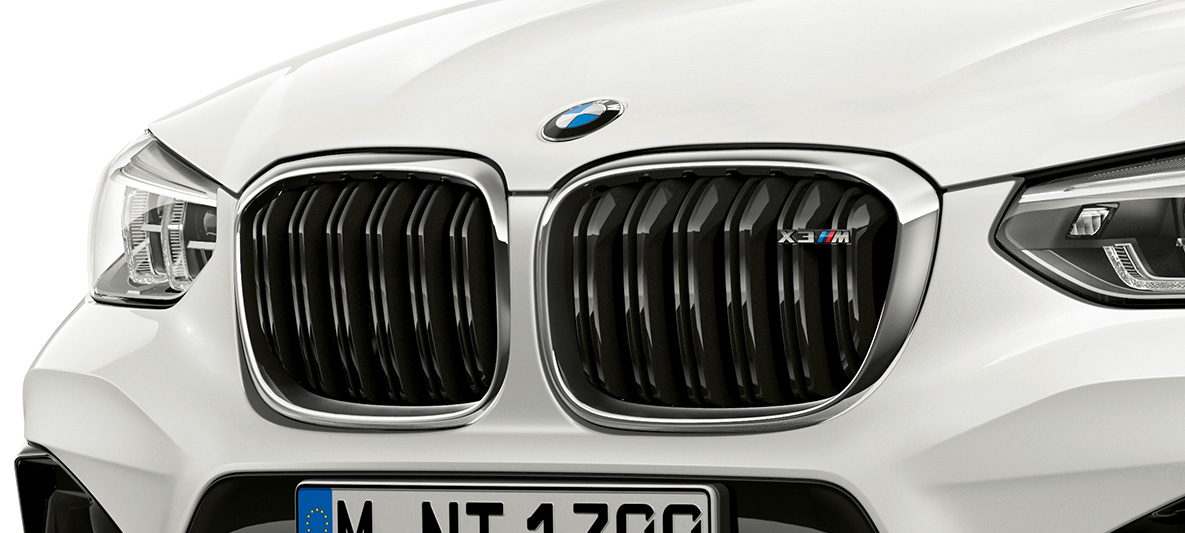 BMW X3 M, parrilla de riñón M. BMW X3 M en Alpine White, exterior, frontal, parrilla de riñón M con elementos destacados cromados y denominación del modelo.