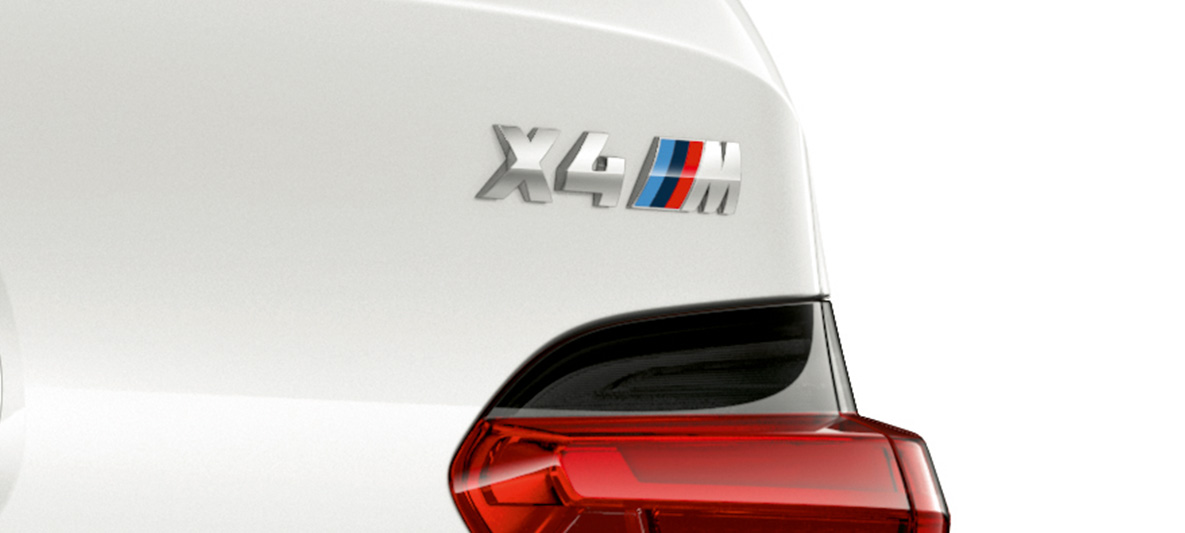 BMW X4 M, designación de modelo. BMW X4 M en Alpine White, exterior, acercamiento de vista trasera con designación del modelo.