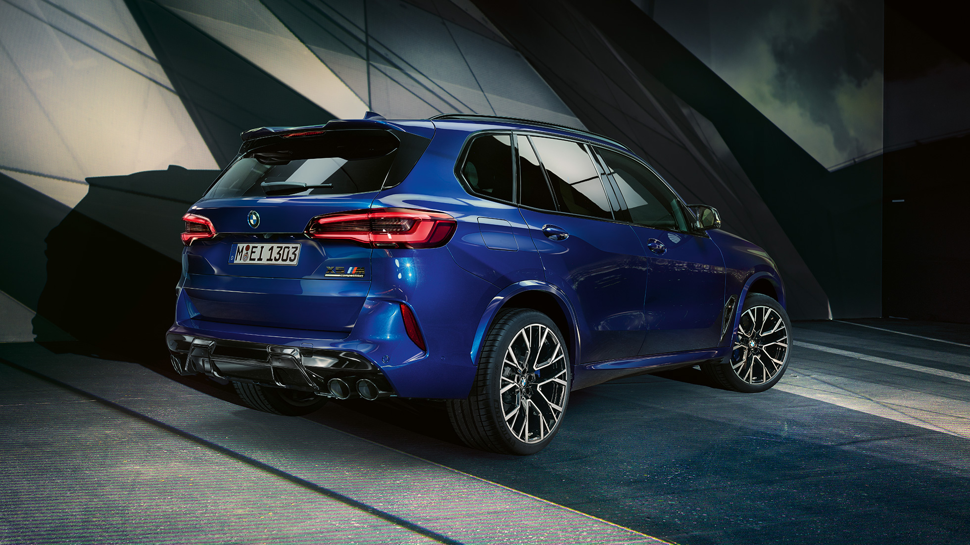 BMW X5 M Competition vista trasera de tres cuartos BMW X5 M Competition con sistema de escape M Sport F95 en color Marina Bay Blue metálico, vista trasera de tres cuartos
