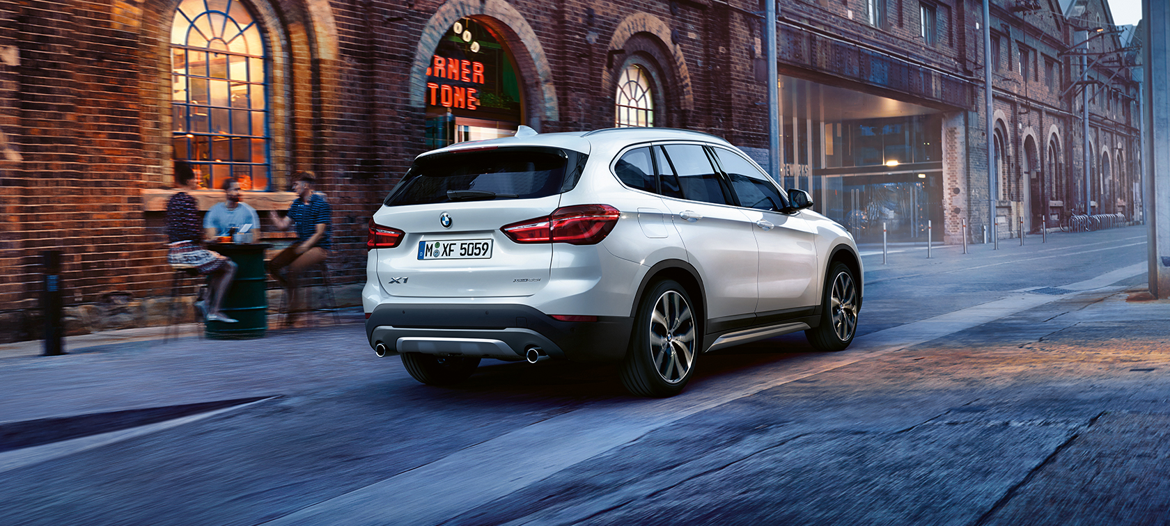 BMW X1 blanco avanzando por las calles de la ciudad BMW X1 blanco avanzando por las calles de la ciudad