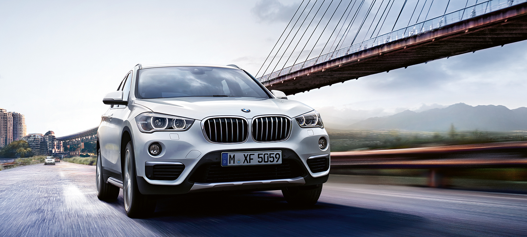 BMW X1 blanco avanzando sobre un puente BMW X1 blanco avanzando sobre un puente