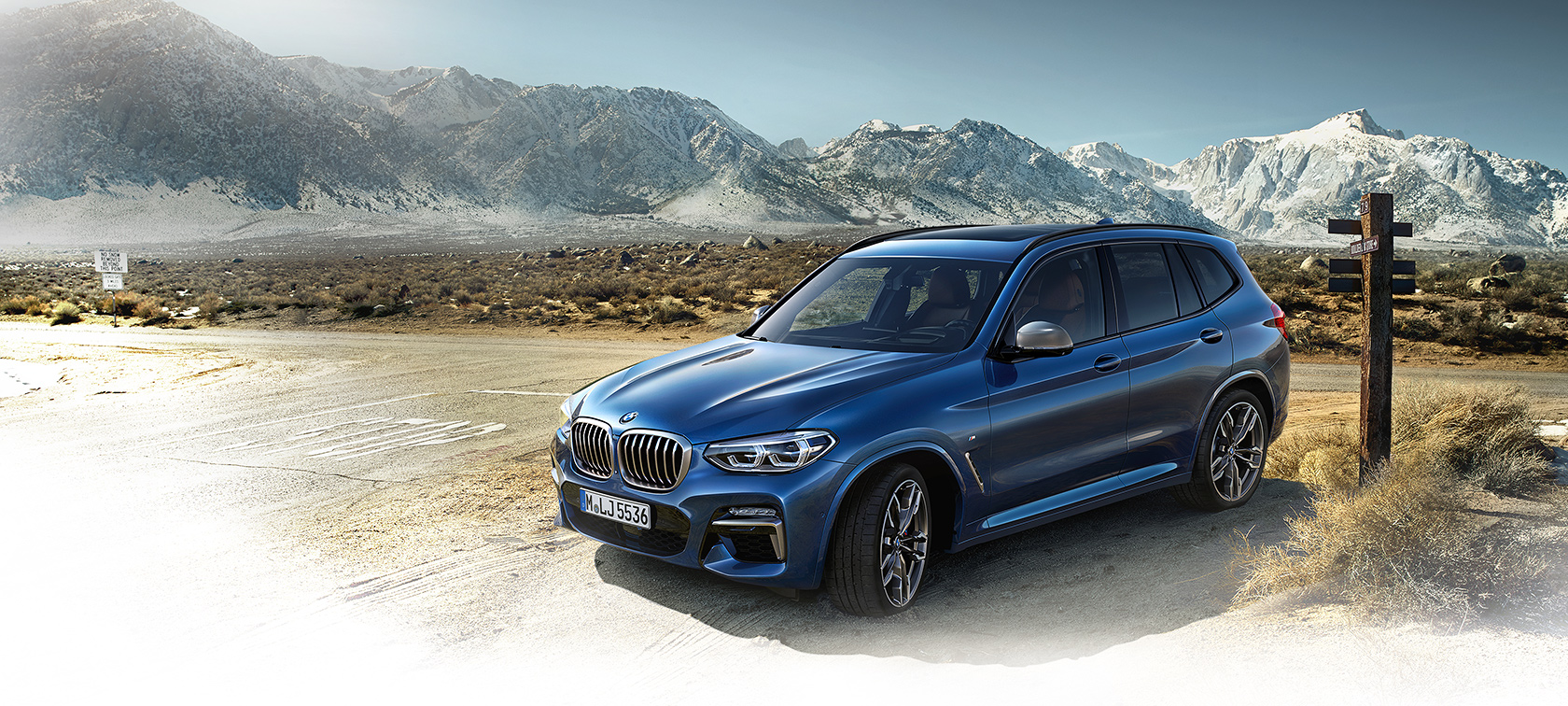 BMW X3 azul con montaña al fondo BMW X3 azul con montaña al fondo