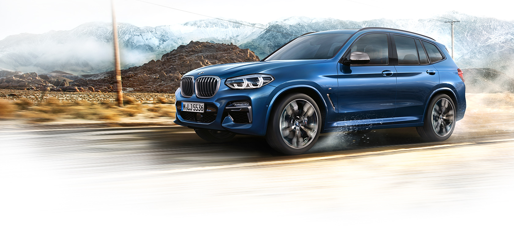 BMW X3 azul: vista lateral izquierda con montaña al fondo BMW X3 azul: vista lateral izquierda con montaña al fondo