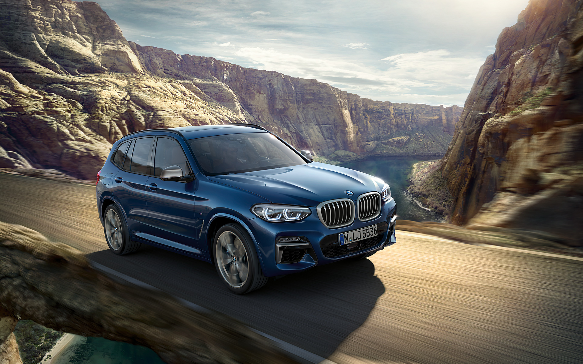 BMW X3 azul avanzando por las rutas de montaña BMW X3 azul avanzando por las rutas de montaña
