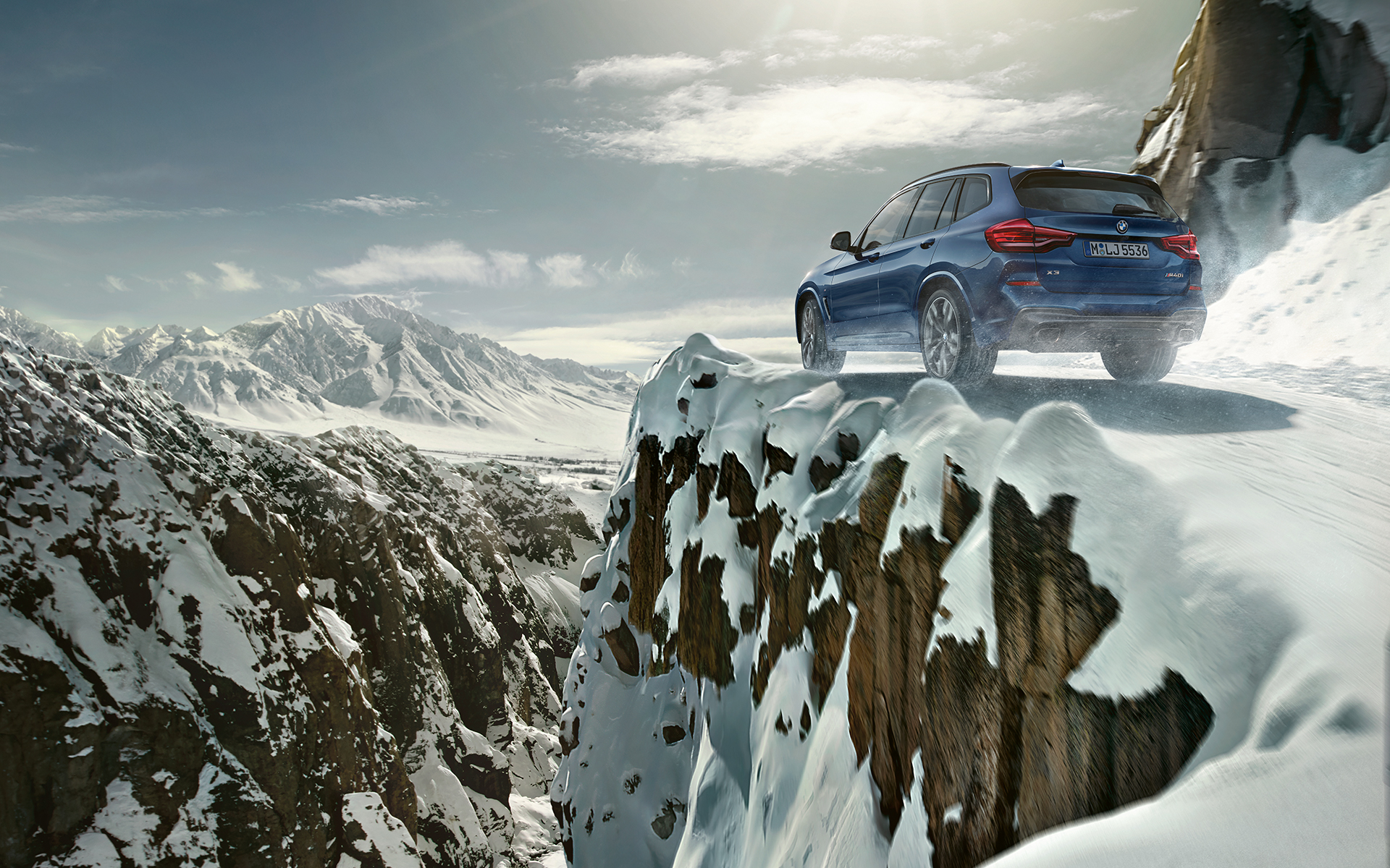 BMW X3 azul en la nieve: vista posterior BMW X3 azul en la nieve: vista posterior