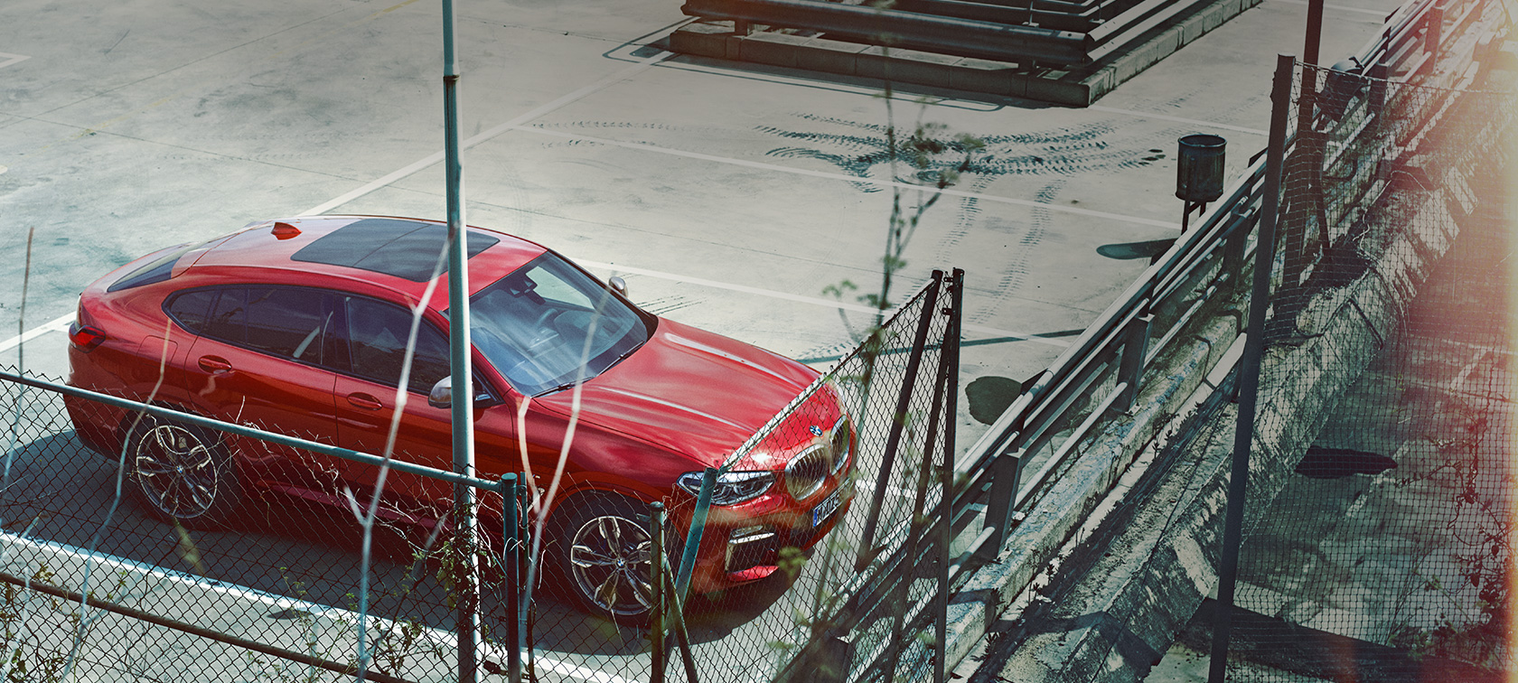 BMW X4 estacionándose Vista aérea del BMW X4 2018 Flamenco Red efecto brillante estacionándose en un lugar de estacionamiento