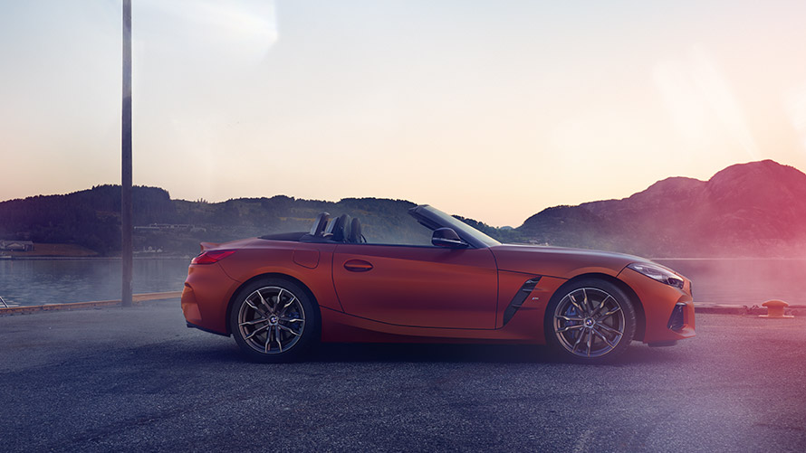 Vista lateral del BMW Z4 naranja Primera Edición Vista lateral del BMW Z4 naranja Primera edición frente a montaña