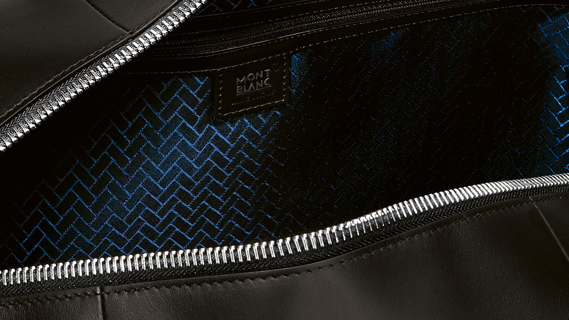 Montblanc para cubierta de pasaporte BMW. La imagen muestra una vista cercana de la superficie estampada de Montblanc para maleta deportiva BMW.