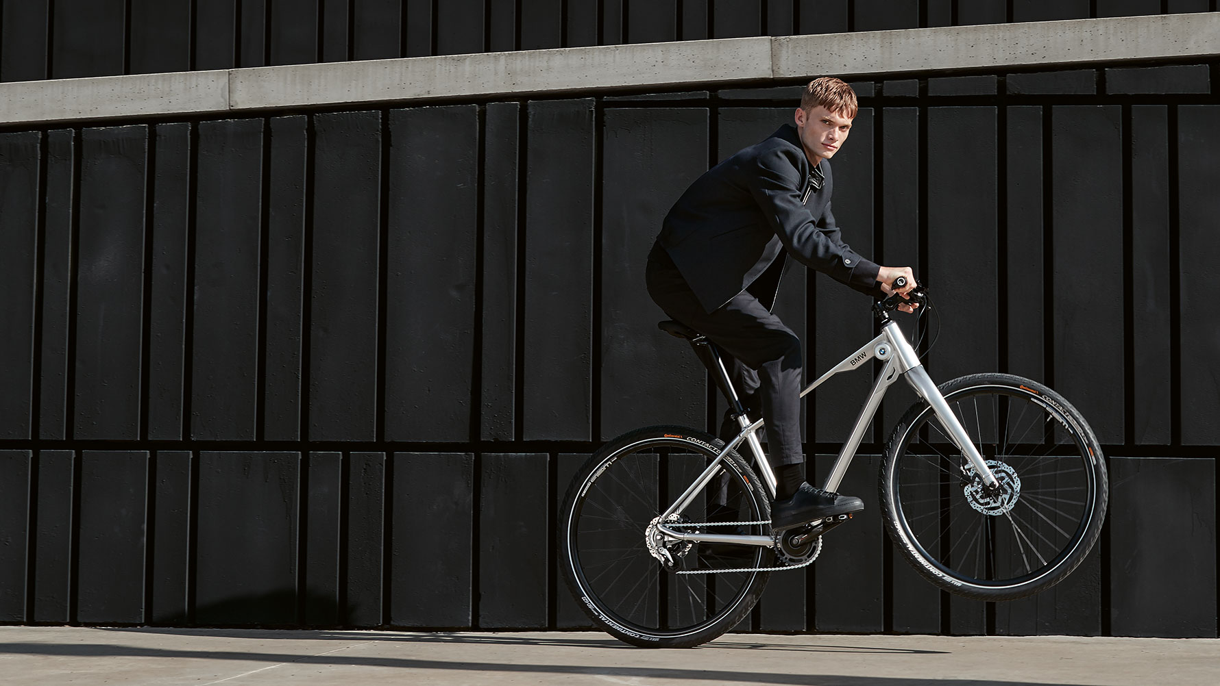 La imagen muestra a un joven haciendo un “caballito” dinámico en una bicicleta BMW Cruise. La imagen muestra a un joven haciendo un “caballito” dinámico en una bicicleta BMW Cruise.