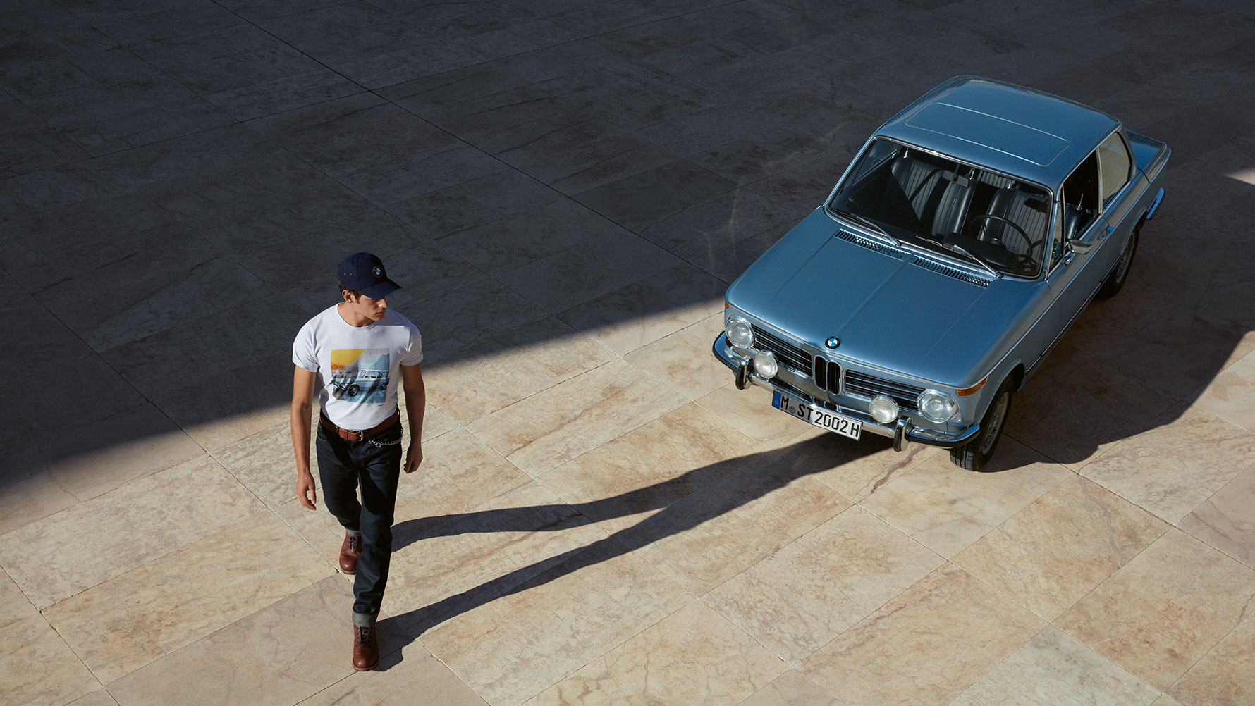 Se muestra un hombre con una playera BMW Classic para hombre admirando un BMW clásico. Se muestra un hombre con una playera BMW Classic para hombre admirando un BMW clásico.
