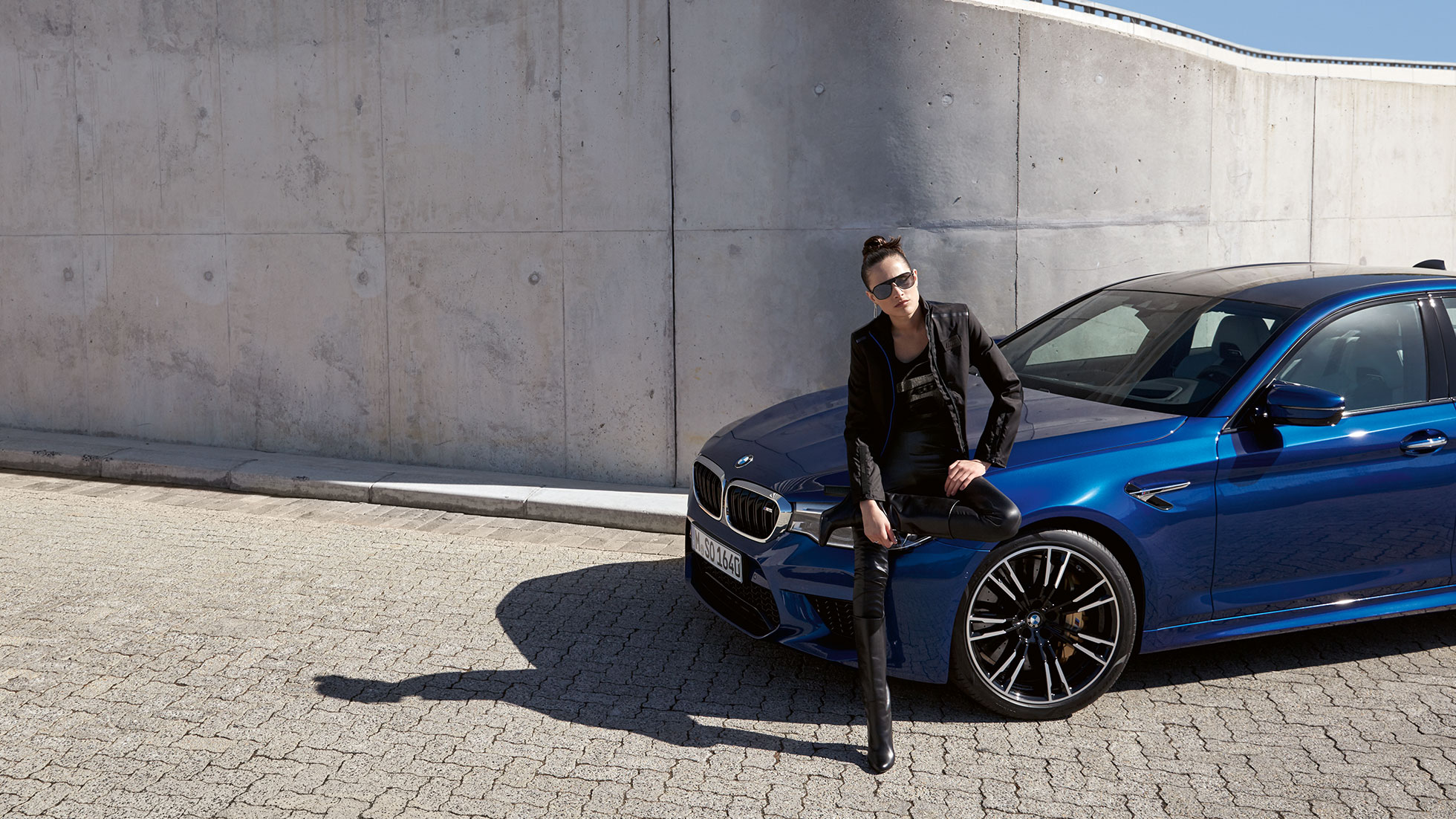 Colección BMW M. Se muestra a una joven con una chamarra BMW M para mujer.