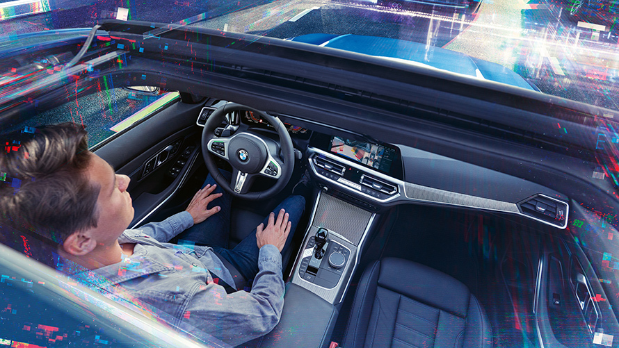 BMW Personal CoPilot: intelligent Parking Man is sitting in a parking BMW using the BMW Personal CoPilot parking assistant