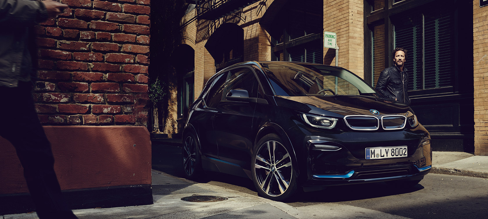 BMW i3. BMW i3 vista delantera de tres cuartos frente a un ambiente urbano.