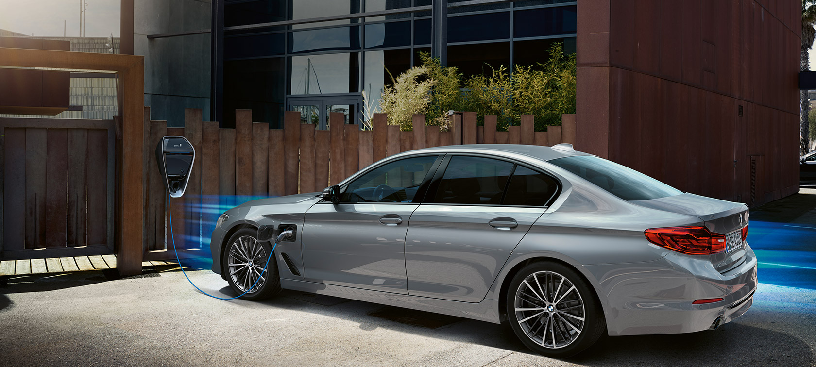 BMW 530e en estación de carga. BMW 530e en vista de tres cuartos en la estación de carga.